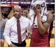  ?? AP/L.G. PATTERSON Arkansas Coach Mike Anderson leads sophomore forward Gabe Osabuohien off the court after the Razorbacks’ loss to Missouri on Tuesday night in Columbia, Mo. ??