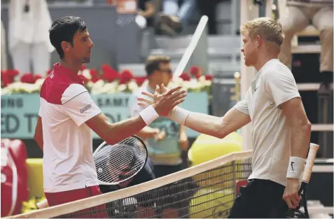  ??  ?? 0 Britain’s Kyle Edmund, right, shakes hands with Novak Djokovic after winning their second-round match at the Madrid Open.