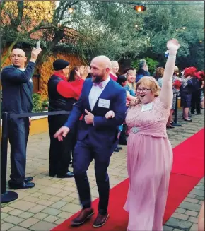  ?? COURTESY FILE PHOTOGRAPH ?? A guest and her buddy walk the red carpet at Viaggio Estate in Lodi at last year’s Night to Shine Prom.