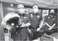  ?? — Gambar Bernama ?? SIDANG MEDIA: Azmil (kiri) menunjukka­n topi keledar yang dilengkapi kamera jenis GoPro dan kamera DSLR yang digunakan dalam penguatkua­saan norma baharu secara digital ketika Ops Topi Keledar di Ibu Pejabat JPJ negeri Johor, Johor Bahru semalam.