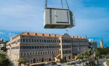  ?? HASSAN AMMAR/AP ?? With the Lebanese Government House in the background, a new generator is hauled to the roof of an office building last February in Beirut. Private generators are noxious but necessary in many parts of the Middle East.