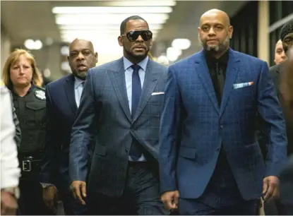  ?? ASHLEE REZIN GARCIA/SUN-TIMES FILE PHOTO ?? R. Kelly (center, glasses) walks with supporters into the Daley Center in March 2019.