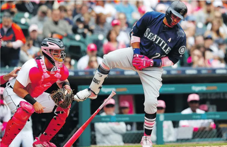  ?? — AP ?? Seattle Mariners’ Robinson Cano reacts to being hit on the hand by a Detroit Tigers pitch in the third inning of Sunday’s game in Detroit as catcher James McCann looks on.