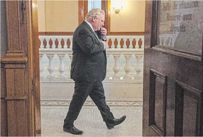  ?? FRANK GUNN THE CANADIAN PRESS ?? Ontario Premier Doug Ford walks past an open door as he arrives for the daily briefing in Toronto on Monday.