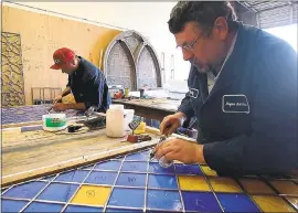  ?? KARL MONDON — STAFF PHOTOGRAPH­ER ?? Felipe Heredia, left, and Andy Lore solder leaded glass panels at Hogan Art Glass on Monday in Campbell. The panels will be used to form a 50-foot-wide backdrop to the altar at the newly rebuilt Holy Cross Church, destroyed by a fire three years ago in...