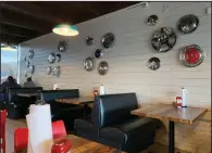  ?? (Arkansas Democrat-Gazette/Eric E. Harrison) ?? Actual hubcaps are part of the wall decor at Hubcap Burger Co.