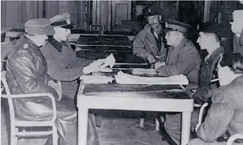  ?? Supplied ?? At age 22, George Molnar (wearing the beret in the second chair on the right side of the table) served as the Germans’ interprete­r during their surrender in Holland on May 5, 1945. In this photo, taken during a preliminar­y meeting that day, Prince Bernhard of Holland is to Molnar’s left and to his immediate right is Canadian General Charles Foulkes. Directly across from Molnar sits Lieutenant-General Paul Reichelt.