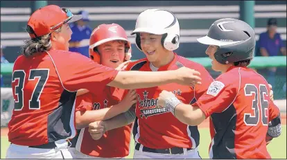  ?? GREG SORBER/JOURNAL ?? Petroglyph’s Reece Maez, in white helmet, is congratula­ted by teammates Zion Springer (37), Ryan Armstrong and Luke Baca (36) after he hit an RBI triple and came home on a throwing error against Altamont.