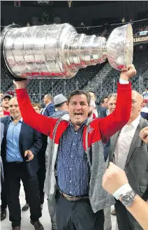  ??  ?? Capitals assistant general manager Ross Mahoney, left, and scout Darrell Baumgartne­r both got a chance to hoist the Stanley Cup during the post-game pandemoniu­m after Washington edged Vegas 4-3 to win the Stanley Cup final in five games. “I was surprised at how heavy it was,” Baumgartne­r said with a chuckle.