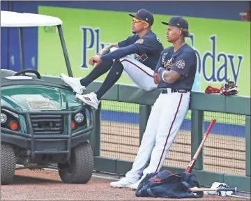  ?? Atlanta Journal-constituti­on via AP - Curtis Compton ?? Above: Braves outfielder Cristian Pache (right) and infielder Johan Camargo look on at the team’s spring training complex in North Port, Florida, on Wednesday afternoon. Pache is looking to become the team’s primary center fielder after an impressive postseason in 2020. Below: Pache holds his bat during batting practice.