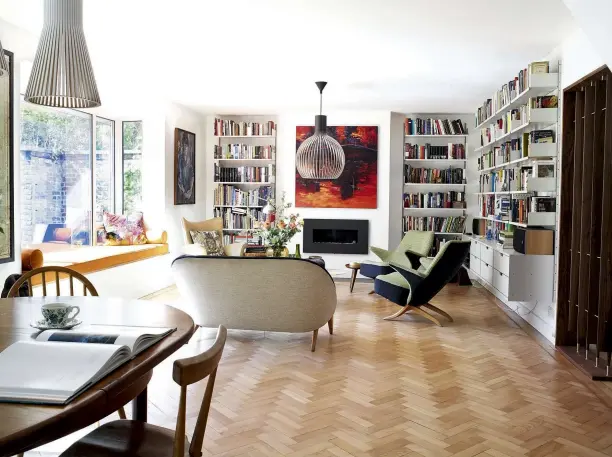  ??  ?? The floating shelving system by Vitsoe enhances the sense of space in the sitting room. ‘Because it’s wall-hung, you see more floor, which makes the room feel bigger,’ says Helena. The bold Russian posters add colour to the monochrome kitchen. ‘The...