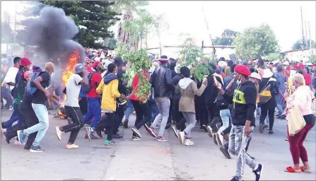  ?? (File pic) ?? Protesters dancing around the tyres which they burnt in front of Matsapha Police Station during a march.