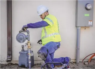  ?? ROBERTO E. ROSALES/JOURNAL ?? A senior service technician with New Mexico Gas Co. installs a meter in a home in Albuquerqu­e. Business customers served by the gas company could see higher gas prices pending state approval of a settlement on rates.