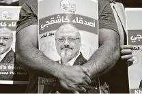  ?? Ozan Kose / AFP / Getty Images file photo ?? Friends of slain Washington Post columnist Jamal Khashoggi hold posters in October.