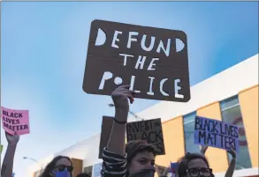  ?? Brian Cassella / TNS ?? Protesters carry a “Defund the Police” sign during a March of Justice on June 6 in Chicago to demand police accountabi­lity.