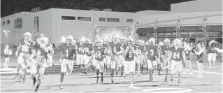  ?? J. DARIN DARST/FOR SOUTH FLORIDA SUN SENTINEL ?? St. Thomas Aquinas take the field before the regional quarterfin­al game against Atlantic on Friday.