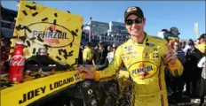  ?? Matt Sullivan/Getty Images ?? Joey Logano applies the winner’s sticker to his No. 22 Pennzoil Ford. Sunday’s win was the 24th of his career.