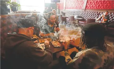  ?? Jeff Chiu, The Associated Press ?? Clockwise from left: Rick Thompson, Keith Baskervill­e and Xavier Baskervill­e smoke marijuana while sitting in the smoking lounge at the Barbary Coast Dispensary early this month in San Francisco.