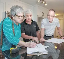  ?? OTTAWA CITIZEN
CHRIS MIKULA/ ?? For buyers Janice and Dan Kennedy, the pre-delivery inspection includes lots of paperwork with Brigil’s Gord Pickup, centre.