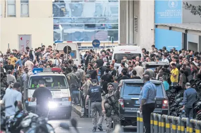  ?? ANWAR AMRO/AFP VIA GETTY IMAGES ?? People and ambulances gather at the entrance of the American University of Beirut Medical Center on Tuesday after explosions killed at least nine and injured around 2,750 in multiple Hezbollah-controlled areas of Lebanon.