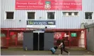  ??  ?? A man wearing a face mask of a character from the film Deadpool walks past the entrance to Wrexham’s Racecourse Ground. Photograph: Phil Noble/Reuters