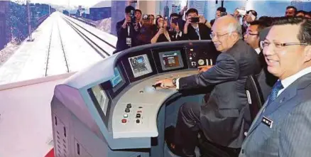  ?? [FOTO AIZUDDIN SAAD/BH] ?? Najib mencuba simulator kereta api berkelajua­n tinggi China Railway sambil diperhatik­an Tiong Lai di Pusat Konvensyen Kuala Lumpur, semalam.