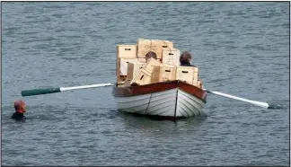  ??  ?? Smugglers ahoy: Crates of ‘whisky’ are rowed ashore yesterday at Portsoy