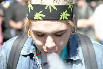  ?? JUSTIN SULLIVAN/ GETTY IMAGES ?? A marijuana user blows smoke after taking a hit from a bong during a 420 Day celebratio­n on “Hippie Hill” in San Francisco’s Golden Gate Park on April 4.