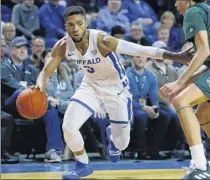  ?? Jeffrey T. Barnes / Associated Press ?? Buffalo guard Jayvon Graves, left, is defended by Ohio guard Jason Preston, right, Tuesday in Buffalo. Graves scored a career-high 26 points, including seven 3-pointers as the Bulls scored 114 points.