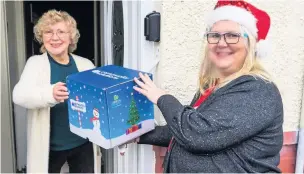  ??  ?? ●● Resident Edna Richardson receiving a box delivered by charity volunteer Kerry Dark