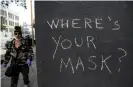  ??  ?? A San Francisco pedestrian passes graffiti encouragin­g masks during the coronaviru­s outbreak. Photograph: Justin Sullivan/Getty Images