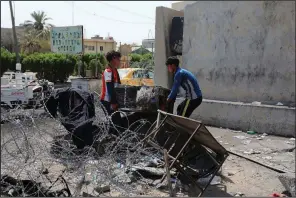  ?? AP/NABIL AL-JURANI ?? Workers remove damaged furniture Saturday from a burned government building in Basra, Iraq.