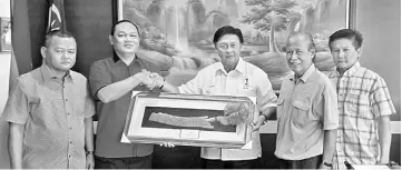  ??  ?? Mawan (centre) receives the memento from SDNU Taman Malihah branch from Churchill, as community leaders (from left) Penghulu Dandan Bujang, Liman Numpang and Penghulu Ting Tiu Look look on.