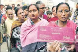  ?? SAMEER SEHGAL/HT ?? (Top) A senior citizen waiting for his turn for exchane of currency notes outside a bank; (above) a woman stands in a queue with her son’s wedding card in Amritsar on Saturday.