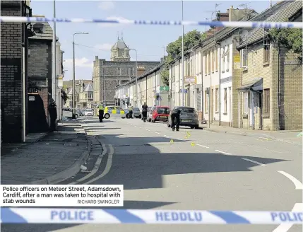  ?? RICHARD SWINGLER ?? Police officers on Meteor Street, Adamsdown, Cardiff, after a man was taken to hospital with stab wounds