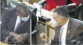  ??  ?? Finance Minister Dr Nigel Clarke (left) chatting with Prime Minister Andrew Holness during the sitting of Parliament last week Thursday.