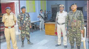  ?? MANOJ DHAKA/HT ?? Police and paramilita­ry personnel stand guard outside a strongroom in Rohtak where electronic voting machines are stored.