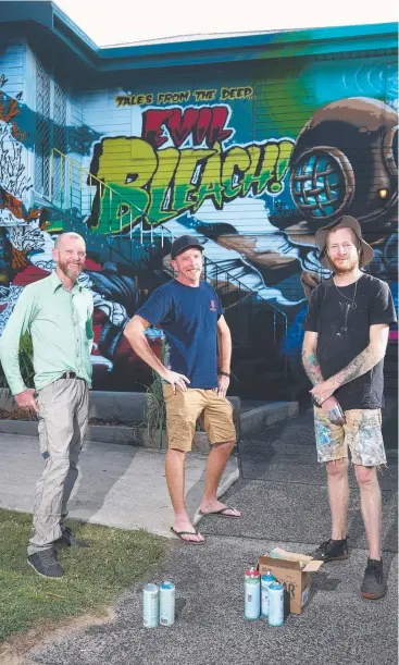  ?? Picture: BRENDAN RADKE ?? SEA CHANGE: Screen Culture Club projection­ist Paul Barron, artist Daniel Wallwork and operations manager of Sea Walls Australia Rick Hayward in front of the finished project.