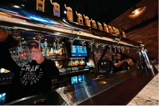  ?? AFP PHOTO ?? A FIRST
Bartenders serve draft beer at Craft brewery in Abu Dhabi on May 7, 2024. This is the first beer made in the conservati­ve Arab Gulf, where alcohol has long been taboo.