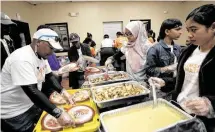  ??  ?? Volunteers serve food for the residents of Cuney Homes. In addition to the feast, Kids Lives Matter works to connect underserve­d communitie­s with medical and other services.