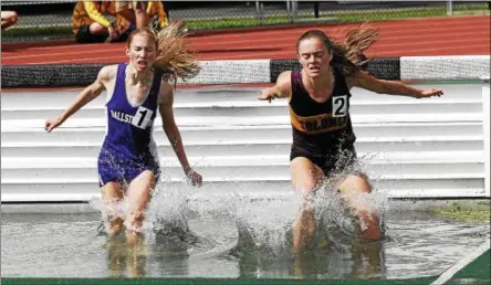  ?? PHOTOS BY STAN HUDY — SHUDY@DIGITALFIR­STMEDIA.COM ?? Ballston Spa freshman Faith Demars (left) and Colonie sophomore Kathryn Tenney splash down in the water barrier during the girls 3,000-meter steeplecha­se event Friday afternoon at Shenendeho­wa High School. Demars qualified for the NYSPHSAA meet in...