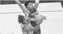  ?? CRAIG LASSIG/AP ?? Heat forward Jimmy Butler goes up for a shot Friday night against Timberwolv­es forward Jaden McDaniels.