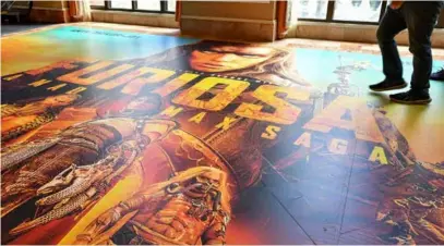  ?? AFP/VNA Photo ?? TO THE MAX: People walk on a giant floor poster of Furiosa: A Mad Max Saga during Cinemacon, the official convention of the National Associatio­n of Theatre Owners at Caesars Palace on Monday in Las Vegas, Nevada.
