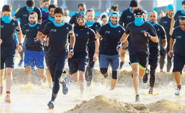  ??  ?? IN THE EYE OF THE STORM ... According to organisers, around 2,800 runners took part at Sandstorm Marmoum, which featured 30 and 40 obstacles for the 5K and 10K races respective­ly. Sheikh Hamdan can be seen running (face covered) with other participan­ts in the Sandstorm obstacle marathon at Al Qudra Lake in Dubai on Friday.