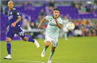  ?? AP PHOTO/JOHN RAOUX ?? Atlanta United’s Thiago Almada, right, gets position on a pass in front of Orlando City’s Antonio Carlos during the first half of an MLS match last September.