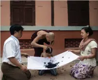  ?? AFP file ?? The parents of a soon-to-be monk hold a sheet to collect the hair shaved from his head during a ceremony initiating him into a Buddhist monastery in Bagan. —