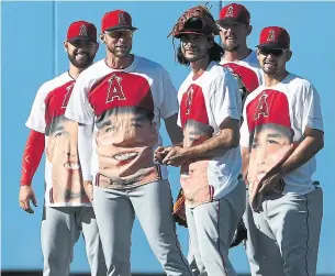  ?? VICTOR DECOLONGON/GETTY IMAGE ?? Los Angeles Angels pitchers Cam Bedrosian, from left, Oliver Drake, Noe Ramirez, Deck McGuire and Taylor Cole show their support for centre-fielder Mike Trout as the American League MVP.