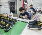  ?? CHINATOPIX VIA AP ?? Workers make sneakers in a factory in Jinjiang city in southeaste­rn China’s Fujian province. China’s economic growth sank to a new multidecad­e low of 6.1% in 2019.