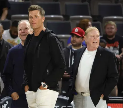  ?? ETHAN MILLER — GETTY IMAGES ?? Former Tampa Bay and New England quarterbac­k Tom Brady, middle, takes in a Las Vegas Aces WNBA game with Raiders and Aces owner Mark Davis, right, and sportscast­er Jim Gray last year in Las Vegas. Brady will reportedly become a minority owner of the Raiders.