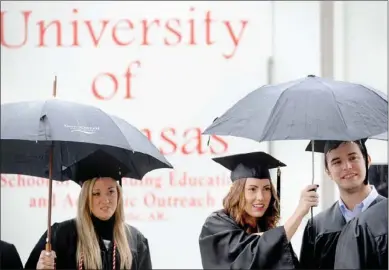  ??  ?? Students wait in the rain
Arkansas at Fayettevil­le.
NWA Media/ANDY SHUPE
outside Barnhill Arena before the start of fall commenceme­nt exercises Saturday at the University of